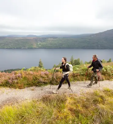 Two hikers on the Great Glen Way with a lake view